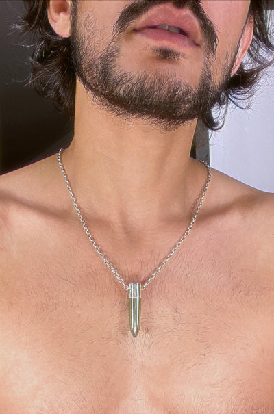 A lingam shaped hanging pyrite crystal pendant on a silver neck chain. 