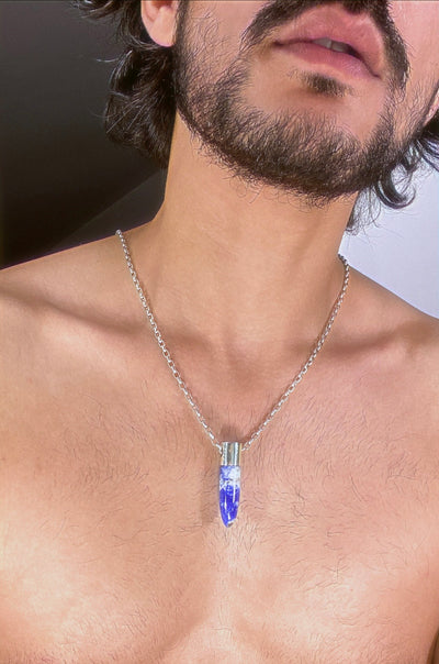 A lingam shaped hanging Lapiz Lazuli crystal pendant on a silver neck chain. . 