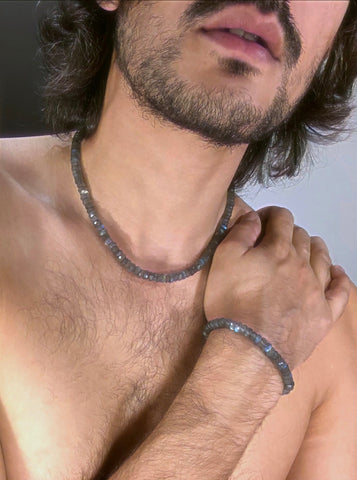 A portrait of an indian boy wearing a labradorite necklace and bracelet. 